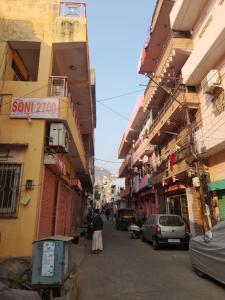 a person walking down a street next to buildings at Pink City Heritage Homestay in Jaipur