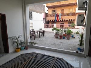 an outside view of a patio with a table and potted plants at Pink City Heritage Homestay in Jaipur +8 photos