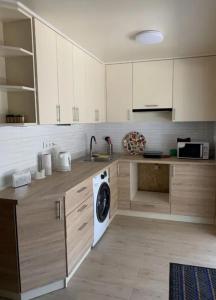 a kitchen with white cabinets and a washing machine at Таунхаус in Košice