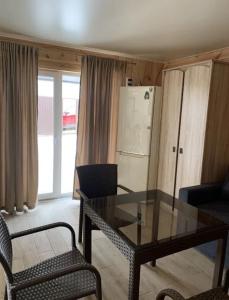 a living room with a glass table and two chairs at Таунхаус in Košice