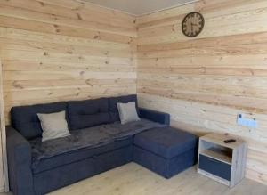 a living room with a blue couch and a clock at Таунхаус in Košice