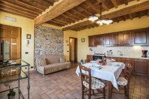 a kitchen and living room with a table and a couch at Historic Apartment With Swimming Pool Near Lucca in Colle di Compito