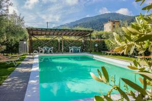 a swimming pool in a yard with a pergola at Historic Apartment With Swimming Pool Near Lucca in Colle di Compito