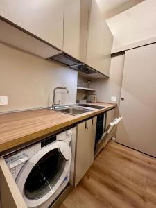a kitchen with a sink and a washing machine at La Pepita - nel cuore del centro in Turin