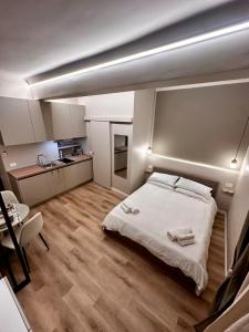 a bedroom with a white bed and a kitchen at La Pepita - nel cuore del centro in Turin