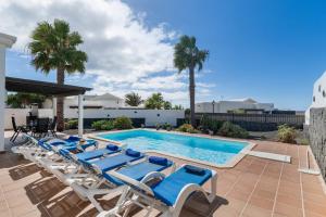 a group of lounge chairs next to a swimming pool at Villa Tania in Playa Blanca