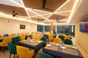 a conference room with tables and yellow chairs at The Grand Sanvika in Ramakkalmedu