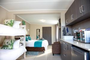 een kamer met 2 stapelbedden en een keuken bij Pinto City Motel East London in East London