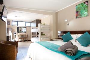 een slaapkamer met 2 bedden en blauwe kussens bij Pinto City Motel East London in East London