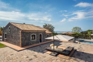 a stone house with a pool and a patio at Villa With Pool And Vineyards Among Etna Vineyards in Santa Maria di Licodia