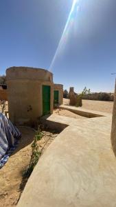 a small building with a green door in the desert at moon retreat in ‘Izbat Mushandid al Kabīrah +55 photos