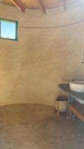 an empty room with a table and a window at moon retreat in ‘Izbat Mushandid al Kabīrah