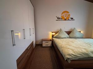 ein kleines Schlafzimmer mit einem Bett und einem Nachttisch in der Unterkunft Haus am See in Biersdorf