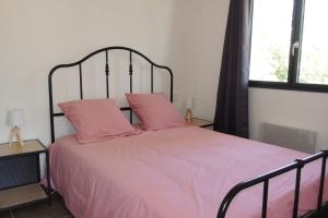 a bedroom with a pink bed with two pink pillows at L'Ortu Di Pisettu -1 in Conca