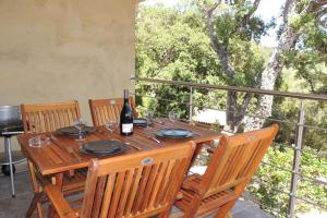 a wooden table with a bottle of wine on a balcony at L'Ortu Di Pisettu -1 in Conca +5 photos