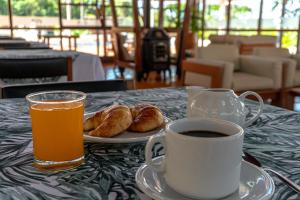 a table with a plate of croissants and a cup of coffee at Hotel ACA Eldorado in Eldorado
