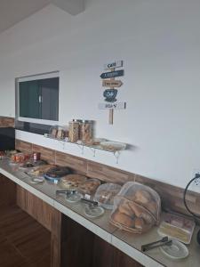 a bakery counter with a bunch of pastries and bread at pousada beira mar suites São Bento in Maragogi