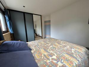 a bedroom with a bed with a quilt on it at Superbe appartement avec terrasse - 5pers - Séez in Séez