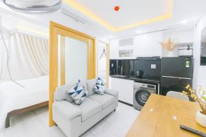 a living room with a white couch and a table at Louis Luxury Apartment & Hotel in Danang
