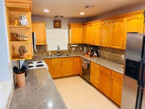 a kitchen with wooden cabinets and stainless steel appliances at Paradise on the Prairie in Oklahoma City