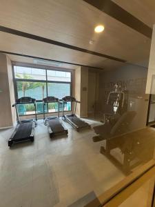 a gym with several tread machines and a large window at Apartamento 300 m do metrô Tatuapé in São Paulo
