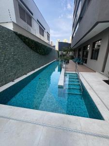 a swimming pool in front of a building at Apartamento 300 m do metrô Tatuapé in São Paulo
