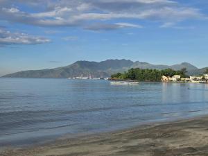 a view of a beach with mountains in the background at wombats beach resort, bar and restaurant in Olongapo