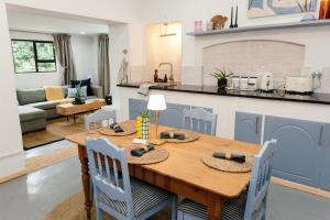 a kitchen and living room with a wooden table and chairs at 19 Mare St Apartments in Howick
