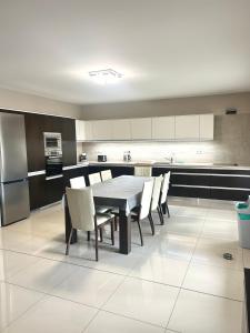 a kitchen with a table and chairs and a refrigerator at Vila Lexus in Veľký Meder