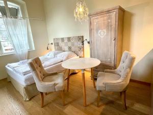 a bedroom with a bed and a table and chairs at ciao-aschau Haus Burg Studio-Apartment101 in Aschau im Chiemgau