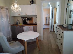 a small kitchen with a white table and a chair at ciao-aschau Haus Burg Studio-Apartment101 in Aschau im Chiemgau