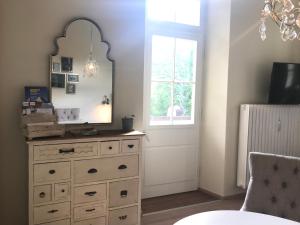 a room with a dresser with a mirror and a window at ciao-aschau Haus Burg Studio-Apartment101 in Aschau im Chiemgau