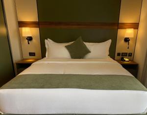 une chambre avec un grand lit blanc avec des oreillers dans l'établissement Coral Beach Hotel & Spa, à Aqaba