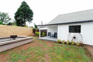 a backyard with a white building and a wooden fence at 19 Mare St Apartments in Howick