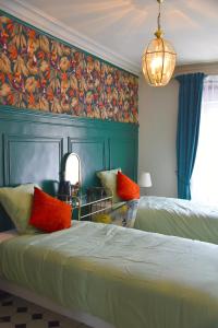 a bedroom with two beds and a painting on the wall at L'Insolite in Gorges
