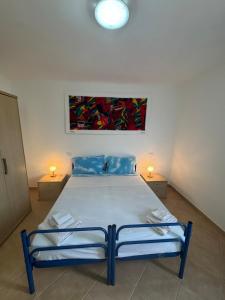 a bedroom with a bed with two lamps on two tables at Tres Caravelas Studio Flats in Santa Maria