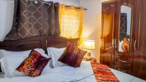 a bedroom with a bed with a large headboard and pillows at KapeView Elegant Suite in Cape Coast