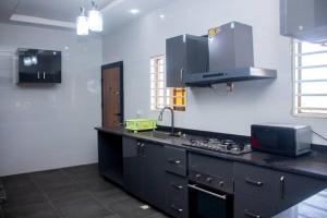 a kitchen with a black counter and a sink at KapeView Elegant Suite in Cape Coast +10 photos