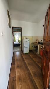 a kitchen with wooden floors and a refrigerator in a room at Nionje Garden Villa in Jambiani