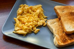 a blue plate with scrambled eggs and toast at Rossio Hostel in Lisbon