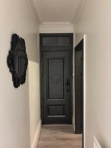 a hallway with a black door with a mirror at Bittern Lodge Homestay with Free Offsite Parking Spacious Kitchen with a Modern Bathroom Near the River Itchen in a peaceful neighborhood in Southampton +4 photos