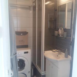 a bathroom with a washing machine and a sink at Alma Apartments in Warsaw