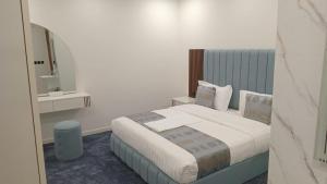 een slaapkamer met een groot bed met witte lakens en kussens bij فيلمست ريزيدنس ابهاVelmist Residence Abha in Abha