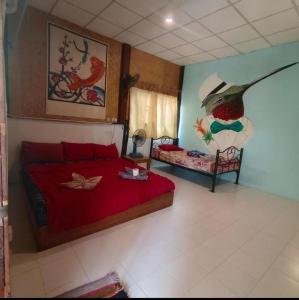 a bedroom with a bed with a red bedspread at Sunny hostel in Pai