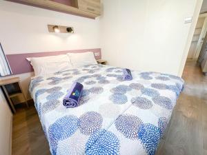 a bedroom with a bed with a blue and white comforter at Happy Camp Mobile Homes in Gitavillage California in Torre di Montalto +20 photos