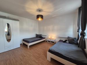 a bedroom with two beds and a mirror at Mikra Homes24 in Glauchau in Glauchau