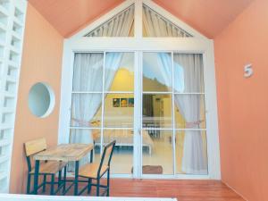 a dining room with a table and a large window at ไวท์เฮาส์ ภูชี้ฟ้า in Ban Tin Pet