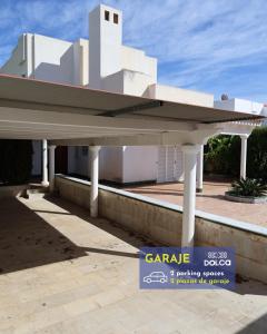 een wit gebouw met een bord ervoor bij Retiros Dolca in La Marina de la Torre