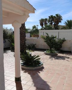 een veranda met twee potplanten in een binnenplaats bij Retiros Dolca in La Marina de la Torre