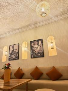a living room with a couch and pictures on the wall at Riad BB Marrakech in Marrakech +7 photos